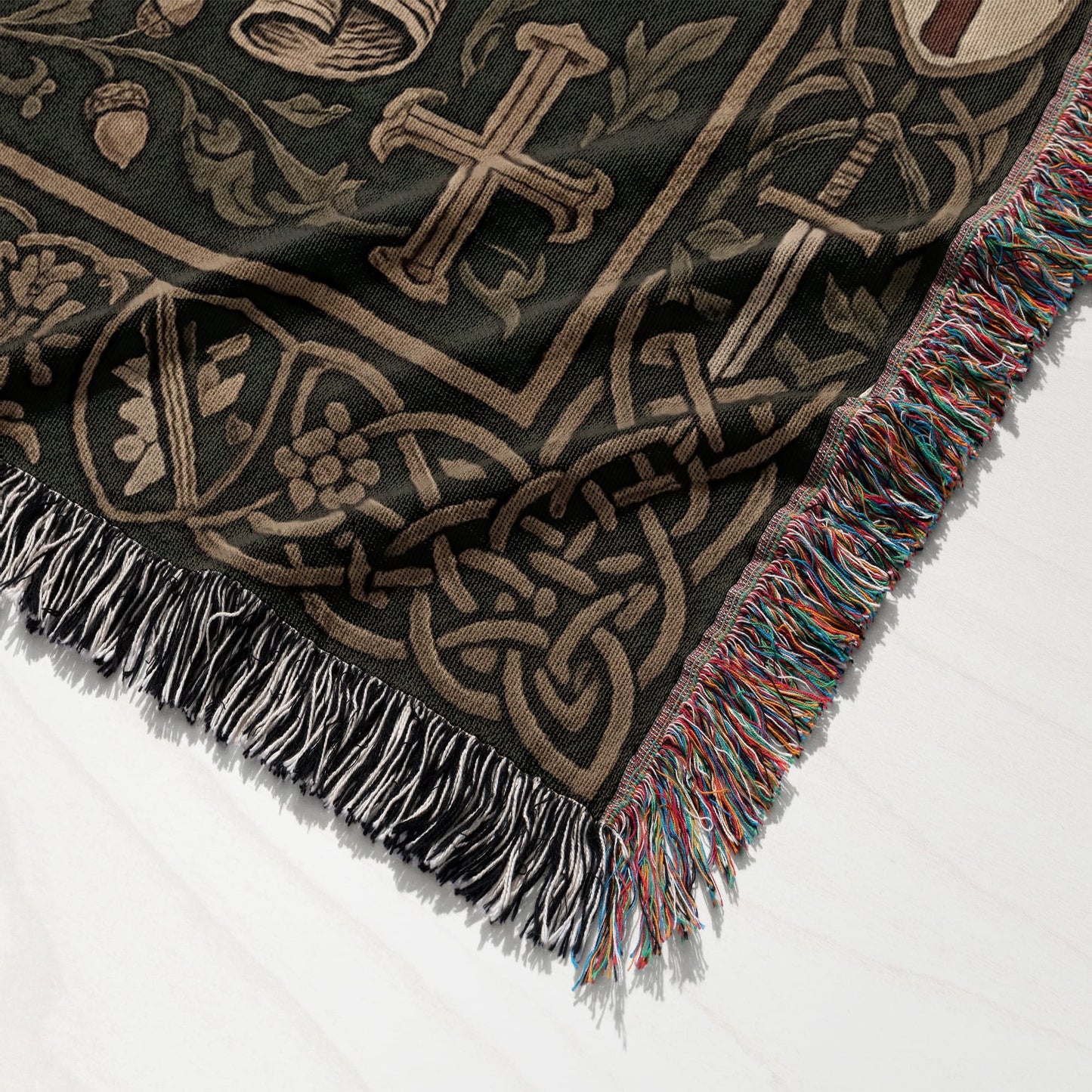 Tapestry throw with Celtic knot, sword, and acorn pattern and tasseled edges.