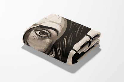 Folded blanket with a portrait of a person's eye and abstract pattern.