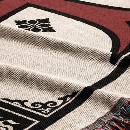 Cream and black throw blanket with decorative border and fringe.