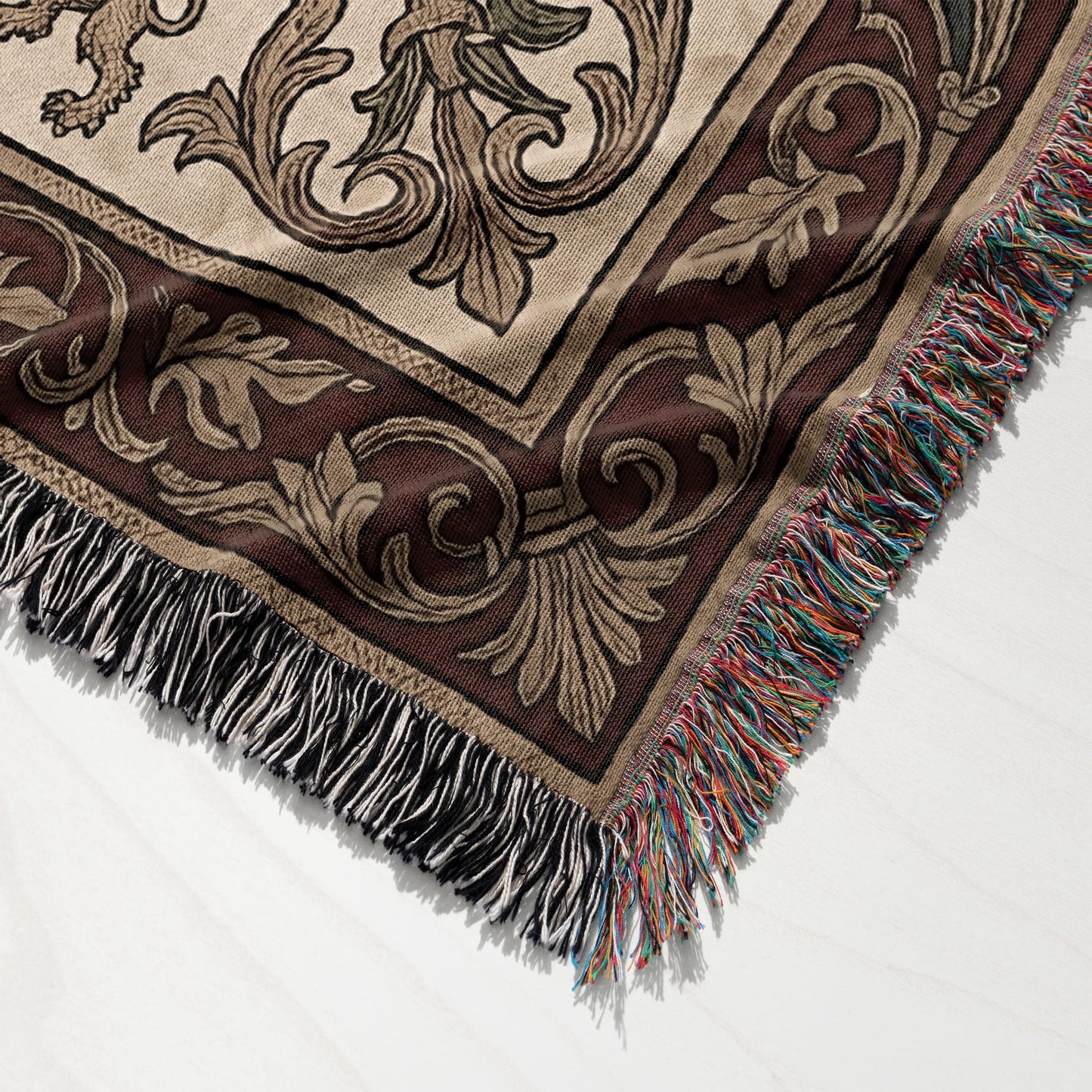 Brown and beige tapestry blanket with ornate scrollwork and colorful fringed edge.