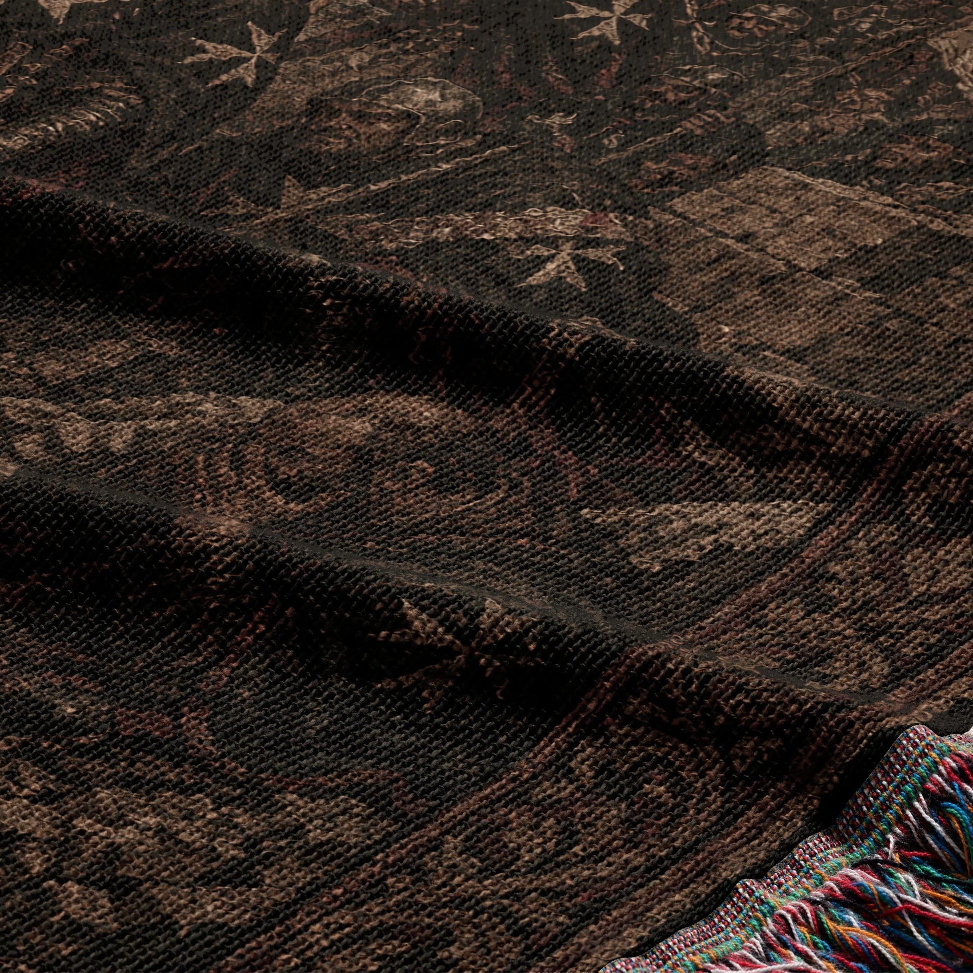 Textured throw blanket with fringe, showing a dark patterned fabric.