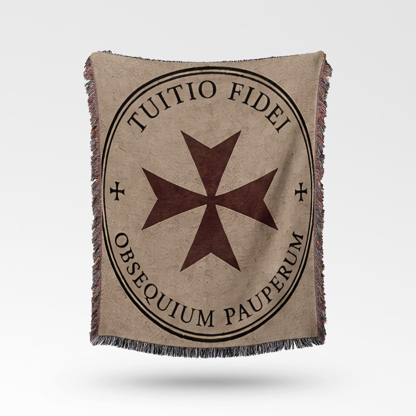 Tapestry blanket with a Maltese cross and Latin text "TUITIO FIDEI OBSEQUIUM PAUPERUM."