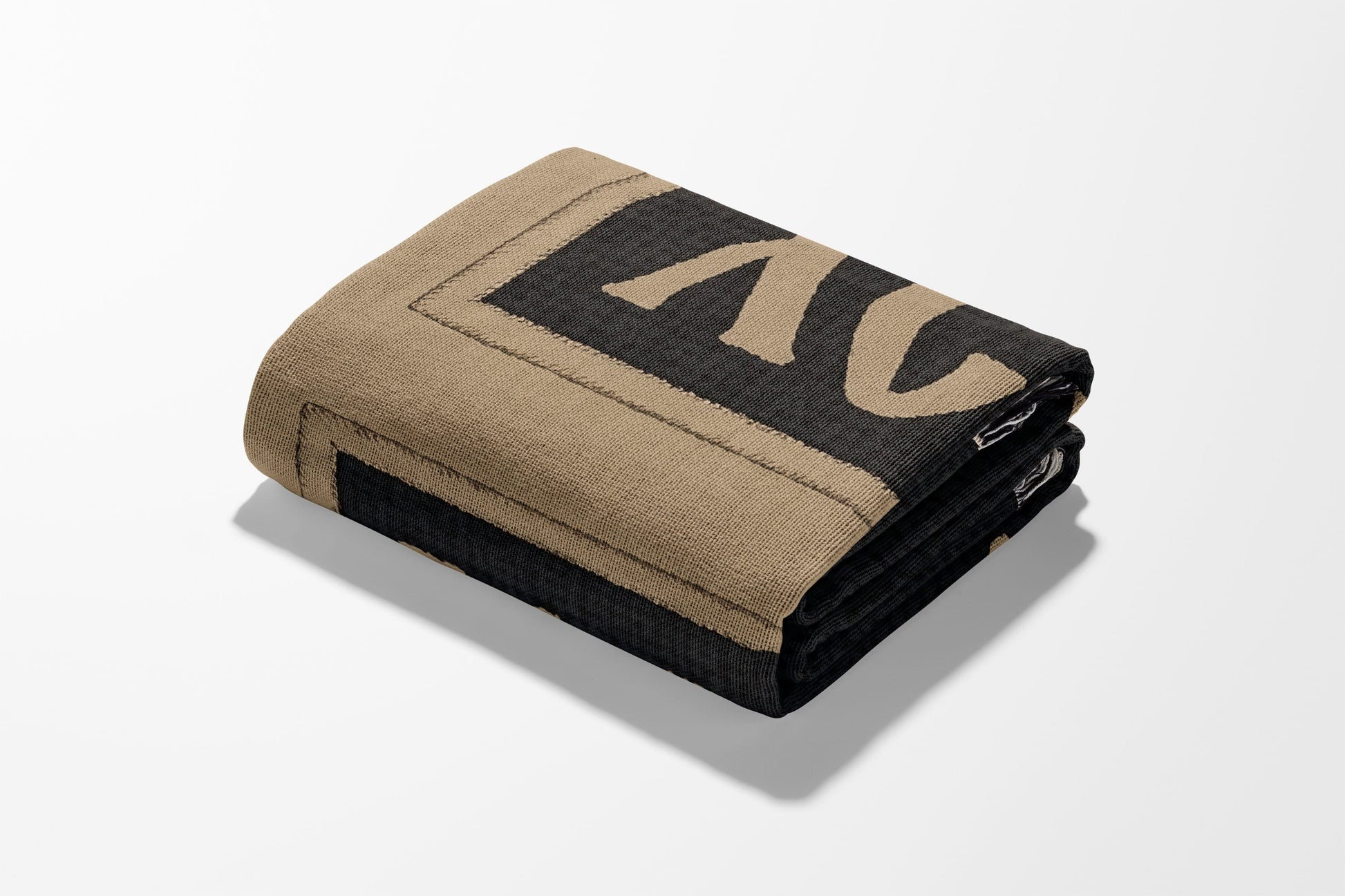 Folded tan and black blanket with a decorative border.