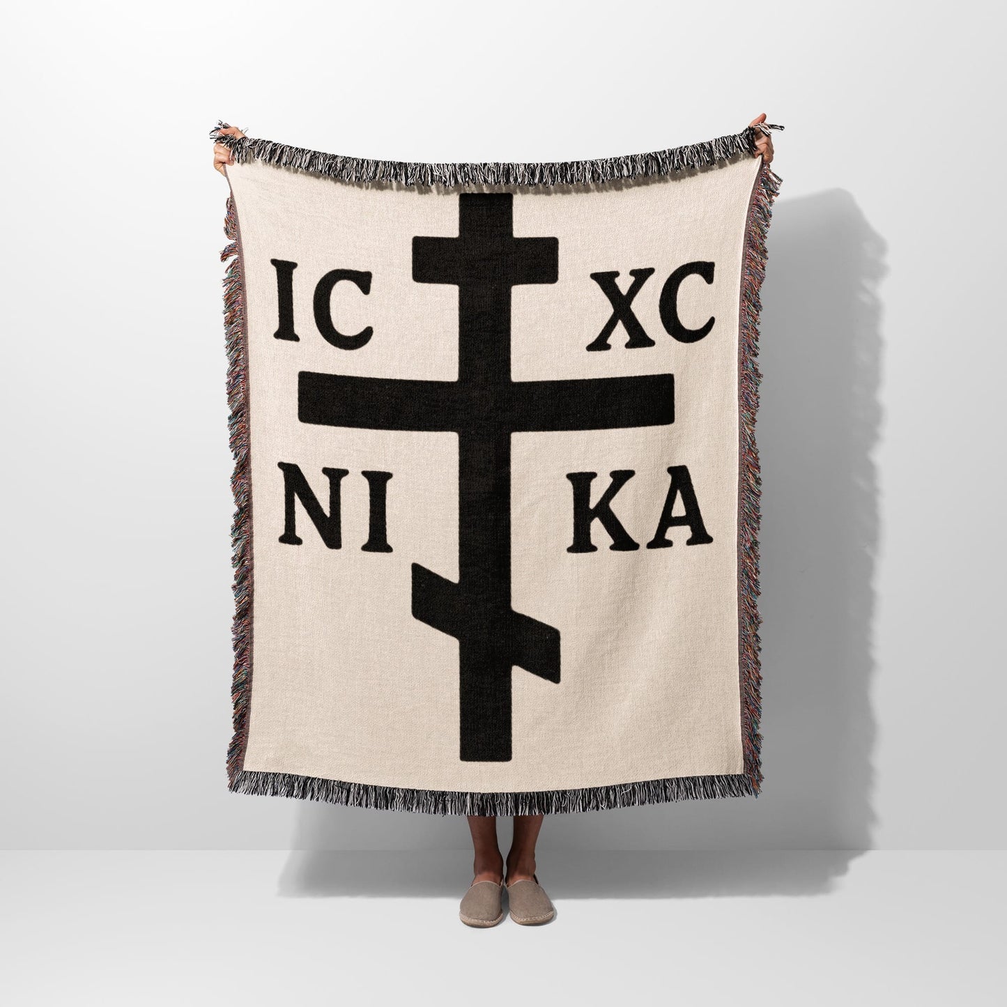Cream blanket with large black Orthodox cross symbol and Greek letters.