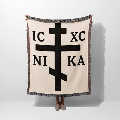 Cream blanket with large black Orthodox cross symbol and Greek letters.