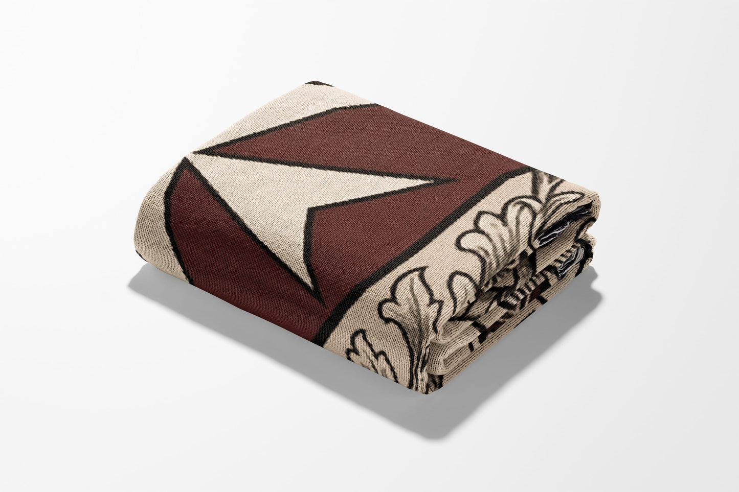 Folded blanket with beige, burgundy, and black geometric and floral pattern.