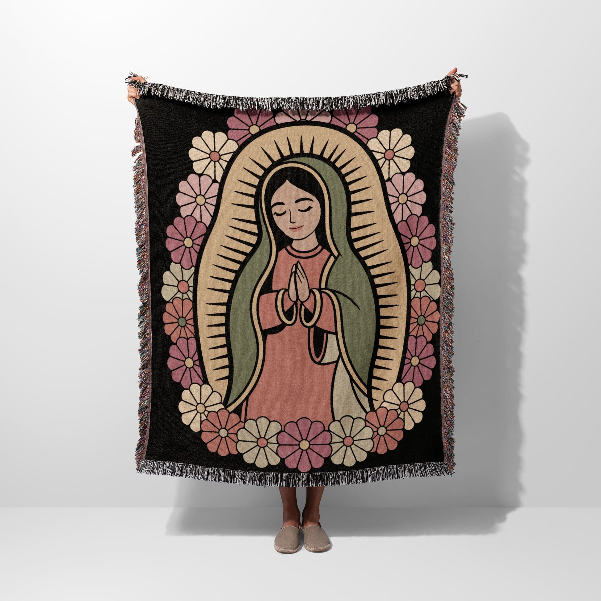 Virgin Mary surrounded by floral border, held by person.
