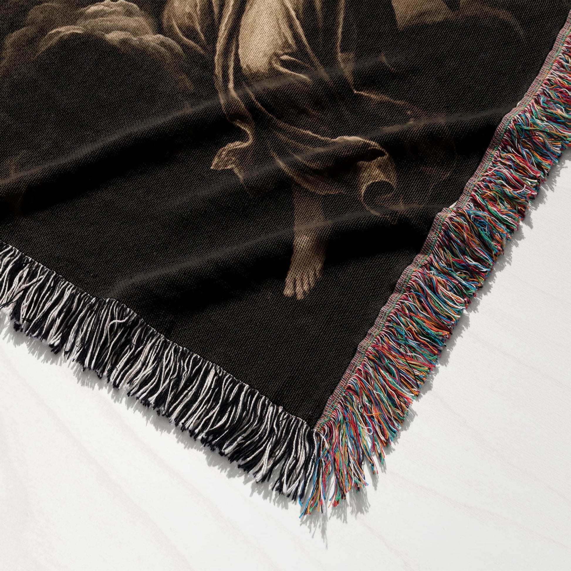 Woven tapestry throw with fringed edges, featuring a classical religious depiction.