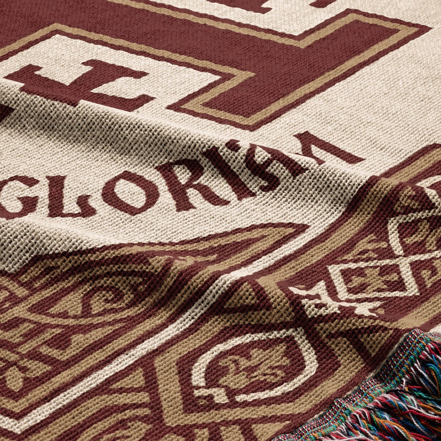 Close-up of a woven blanket with "GLORISMA" and decorative patterns.