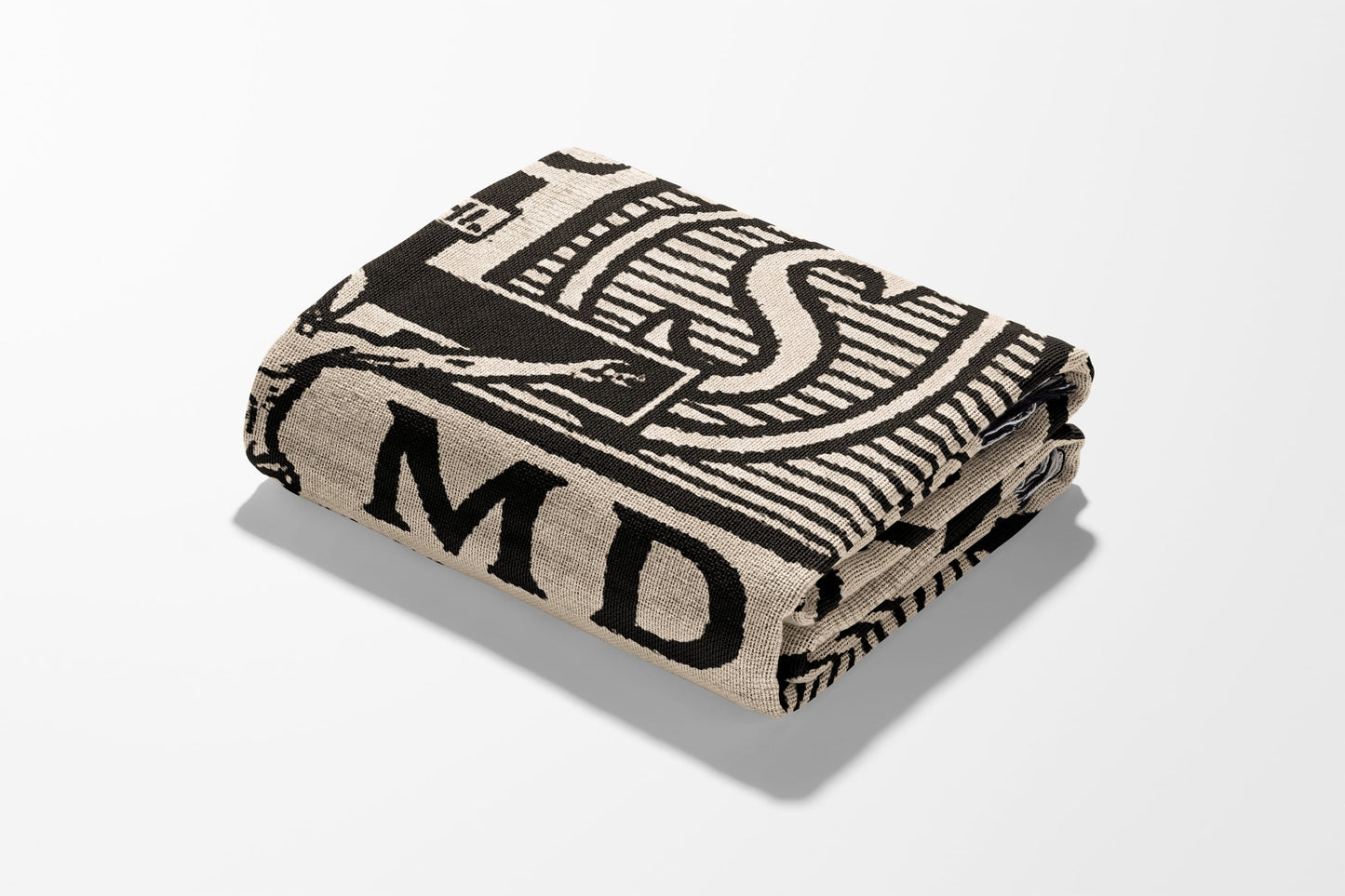 Fawn and black blanket with MD and a stylized S pattern folded on a white background.
