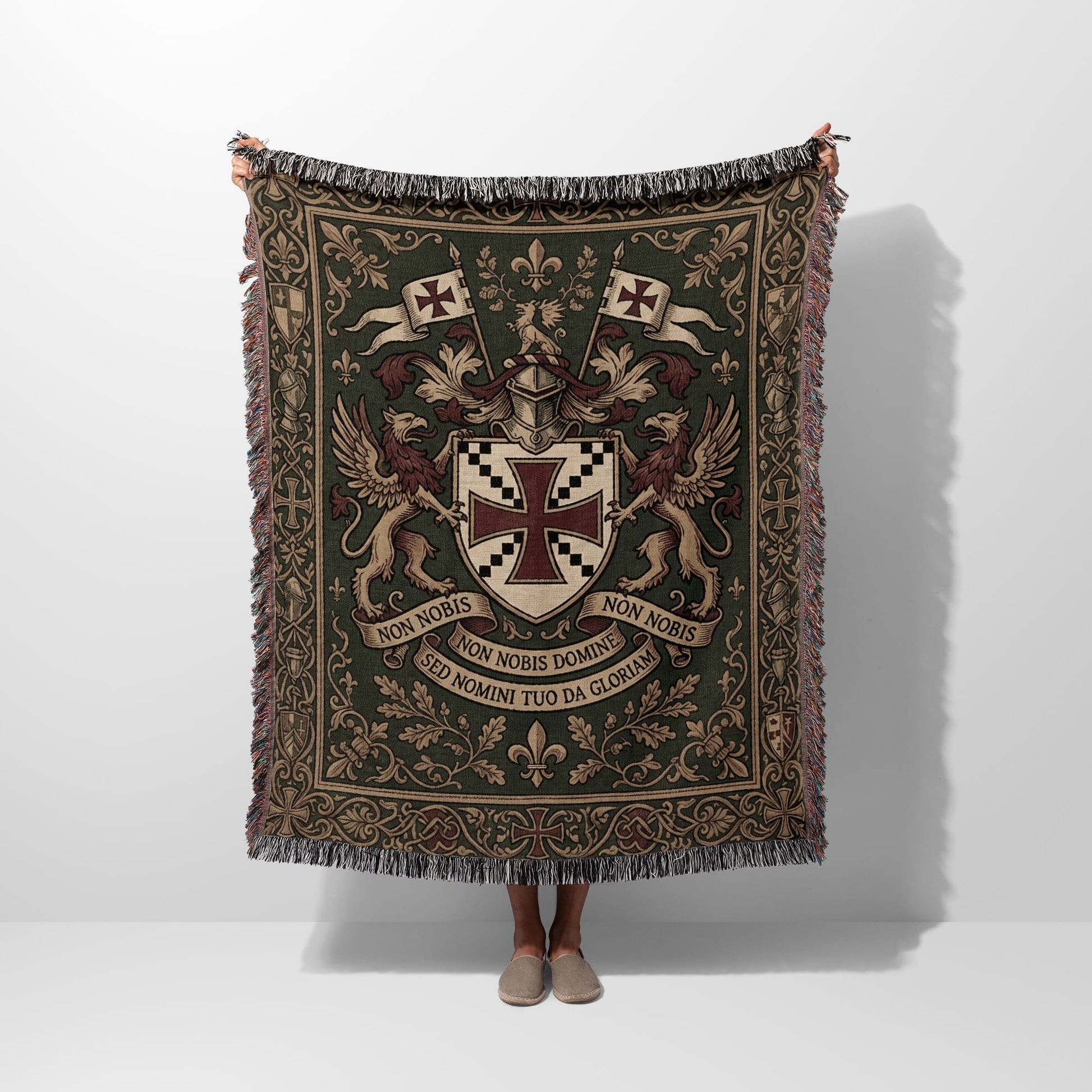 Green woven tapestry blanket with coat of arms, griffins, and Latin text.
