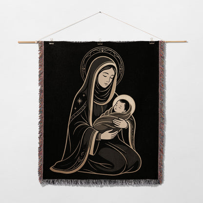 Religious tapestry depicting Mary holding baby Jesus, against black background.