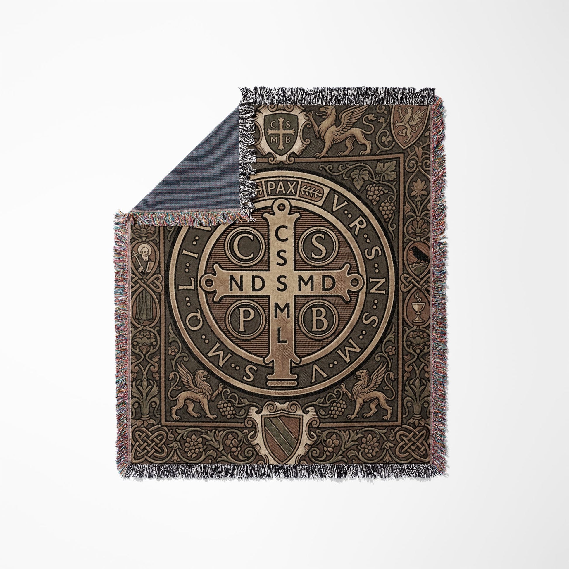Woven throw blanket with Saint Benedict medal and ornate borders on white background.