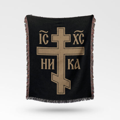 Black woven throw blanket with a gold Byzantine cross and text.