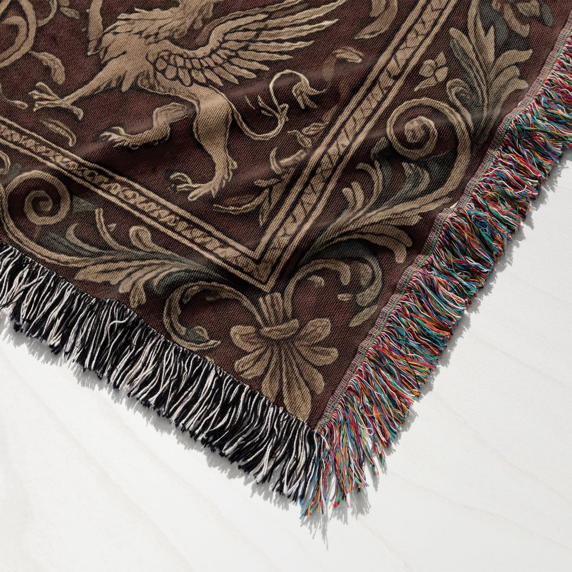 Brown woven blanket with griffin and floral pattern, fringed edges.