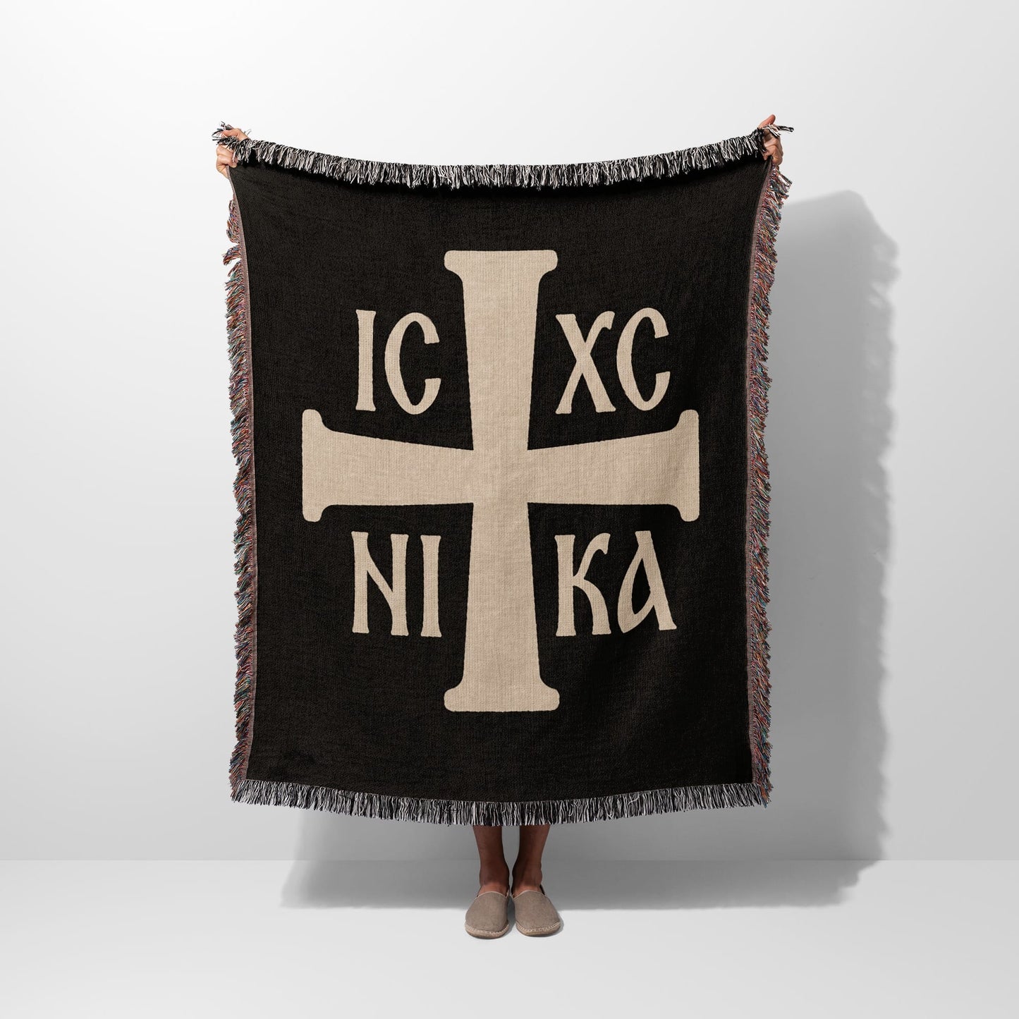 Black throw blanket with a large tau cross and Greek lettering.