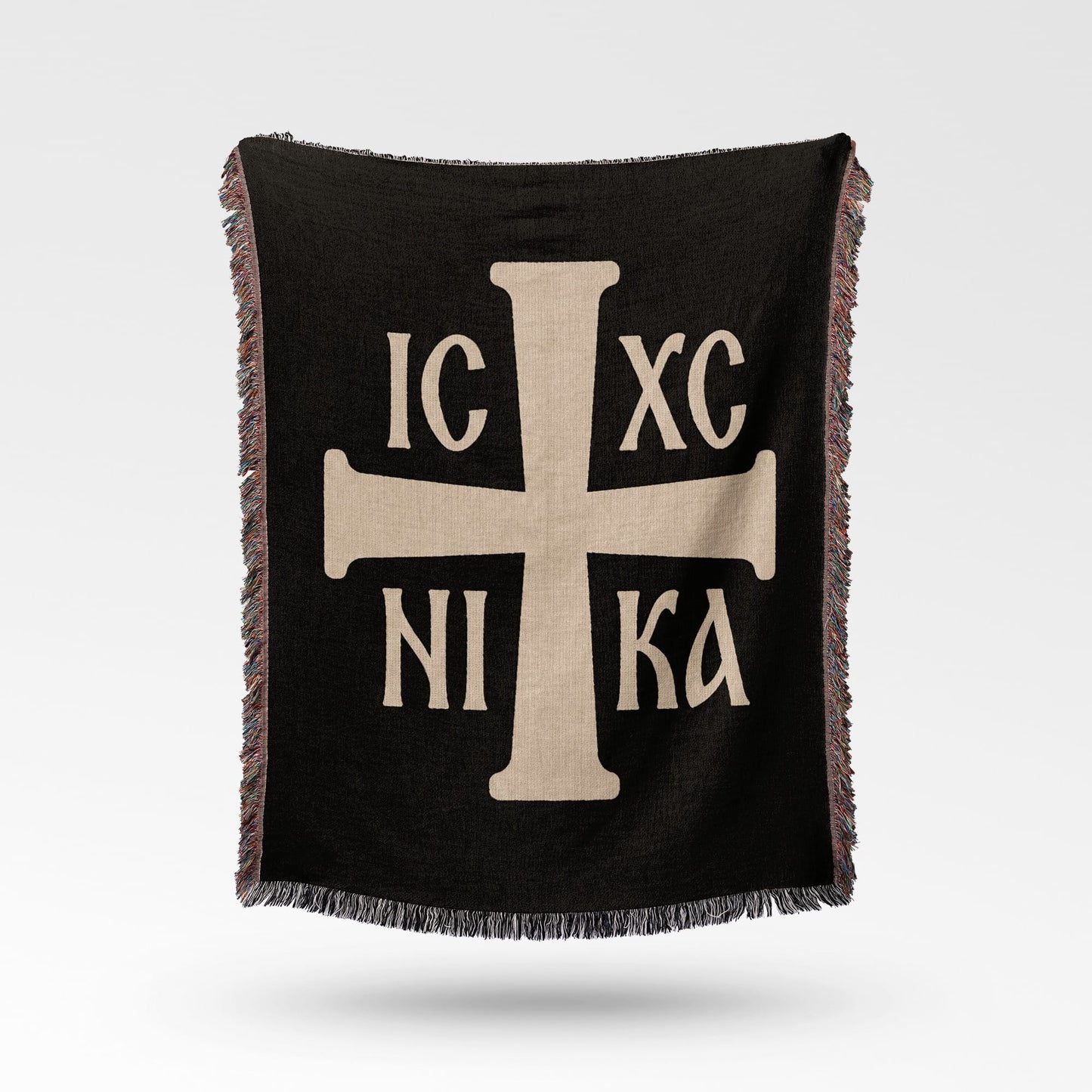 Black throw blanket with a light tan Greek Orthodox cross and Greek lettering IC XC NI KA.