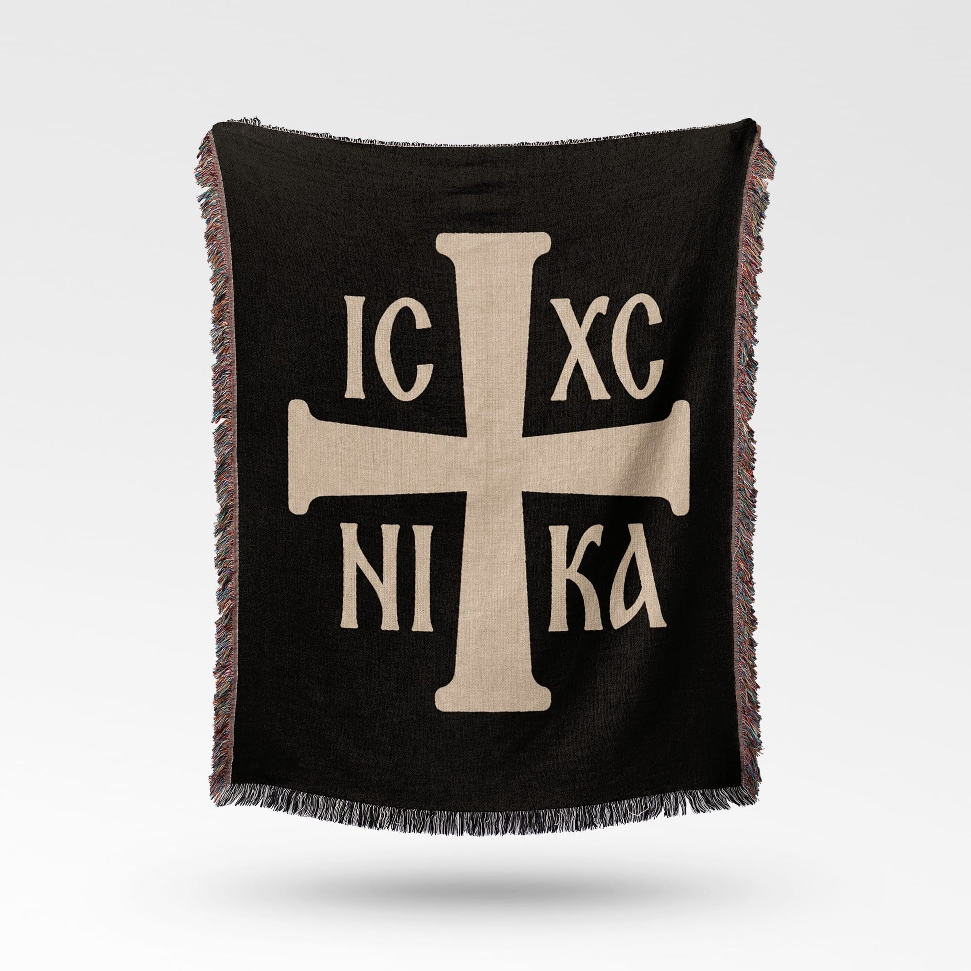 Black throw blanket with a light tan Greek Orthodox cross and Greek lettering IC XC NI KA.