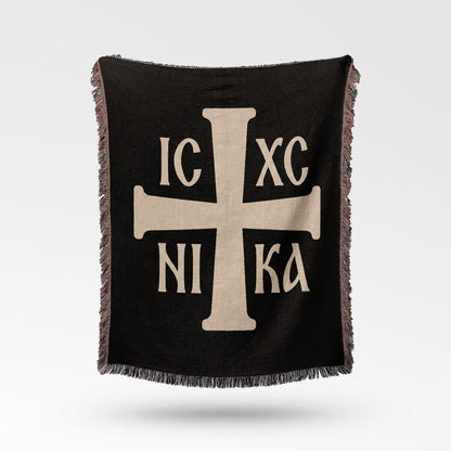 Black throw blanket with a light tan Greek Orthodox cross and Greek lettering IC XC NI KA.