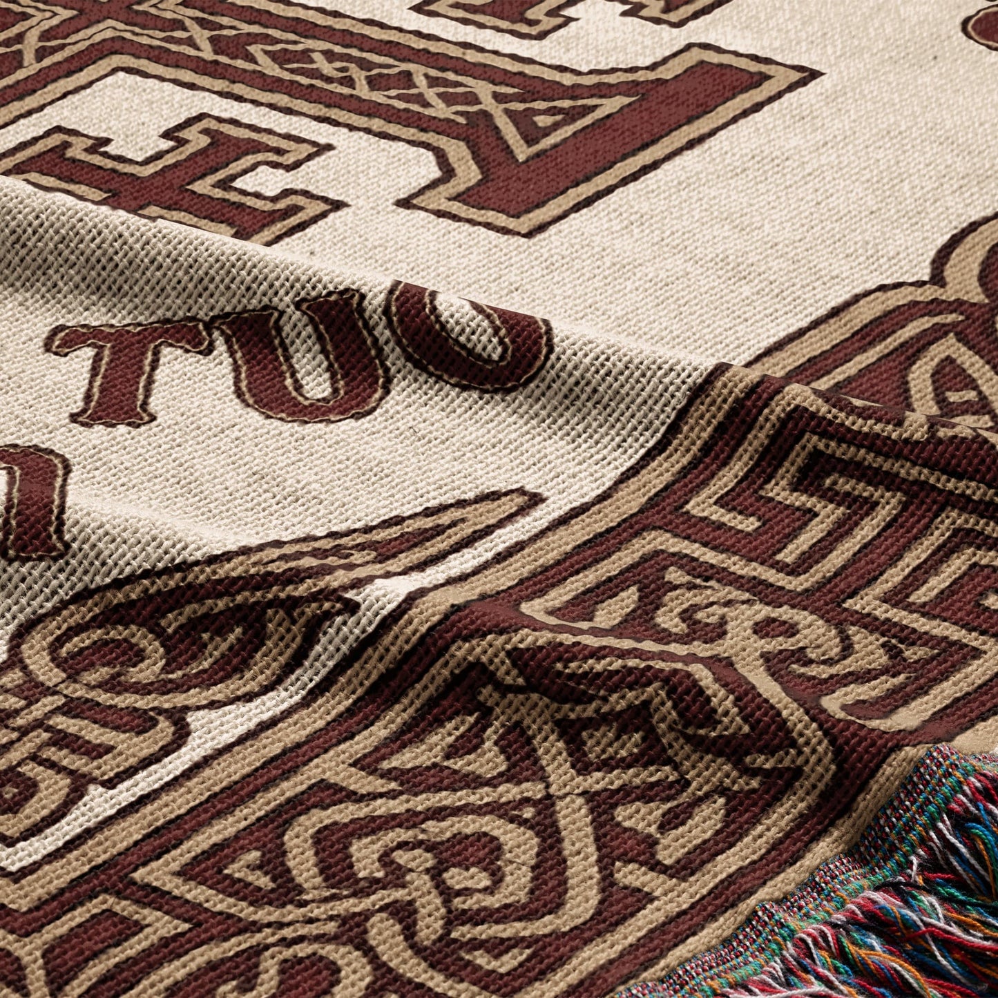 Tapestry throw with tan and brown knotwork and text "TUO".