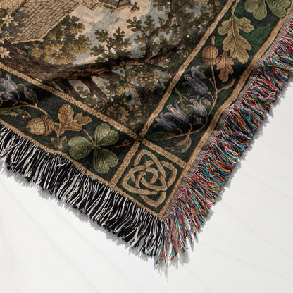 A woven tapestry blanket featuring a medieval landscape scene and a decorative floral border with multi-colored fringe.