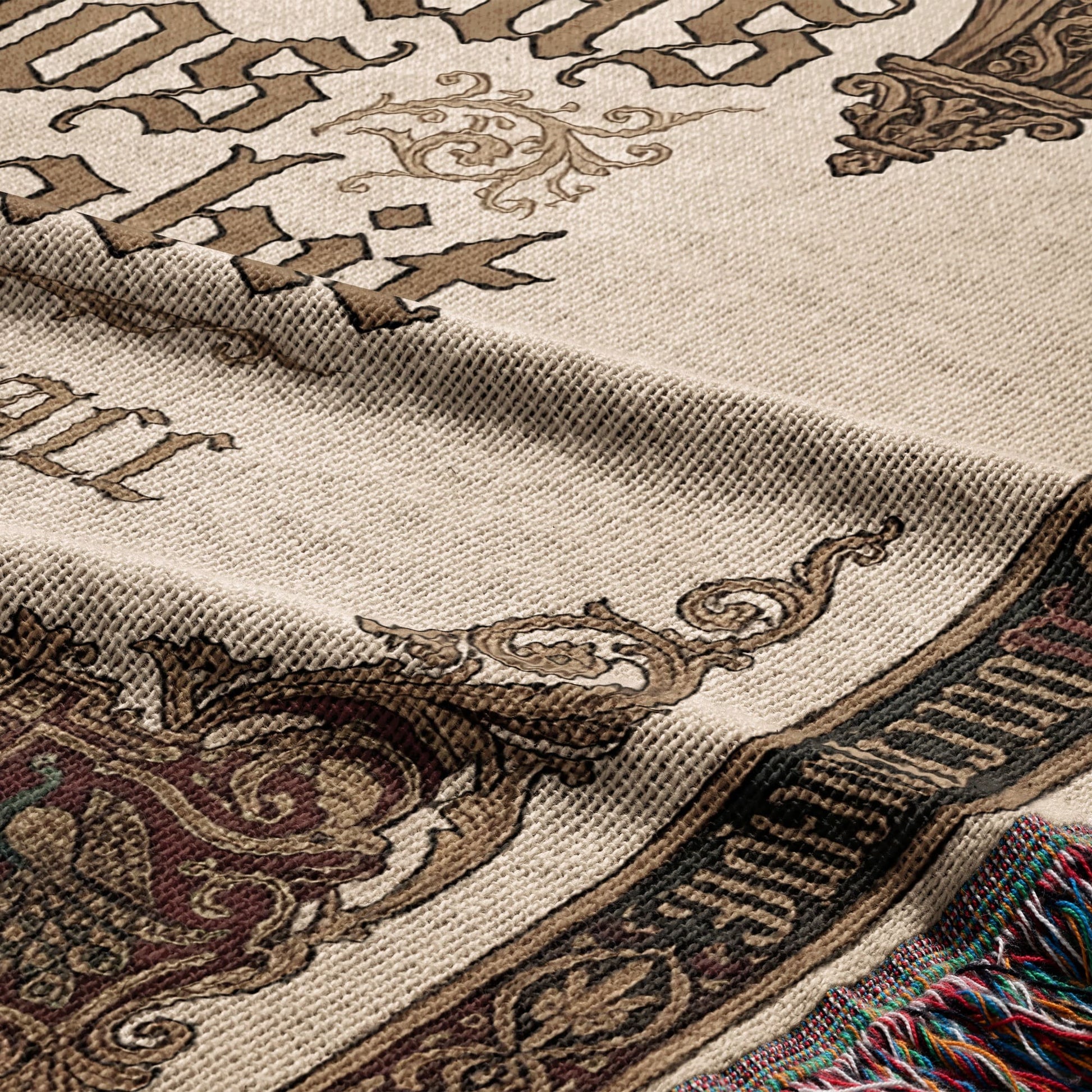 Woven blanket with ornate brown and burgundy scrollwork and text.