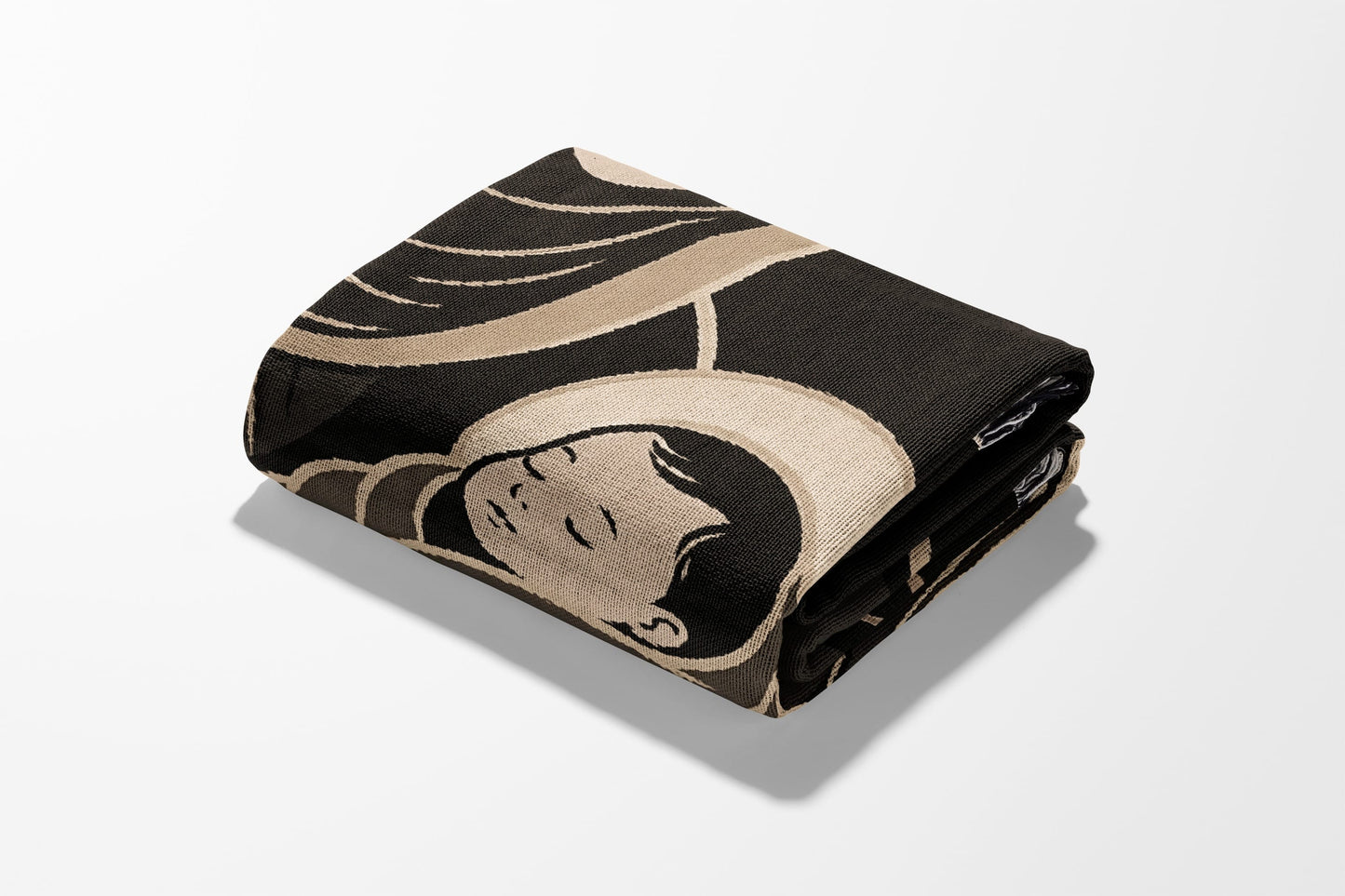 Folded blanket with a stylized, sleeping figure design on a white background.