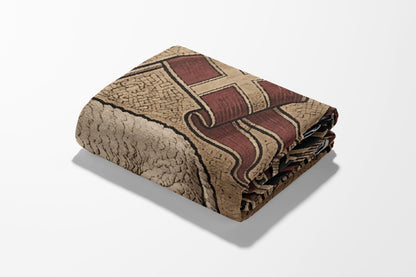 Folded blanket with a geometric pattern of brown and red on a white background.