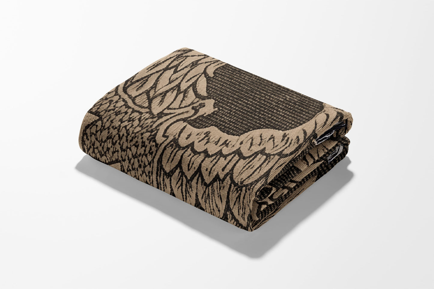 Folded blanket with intricate black and tan eagle feather pattern.