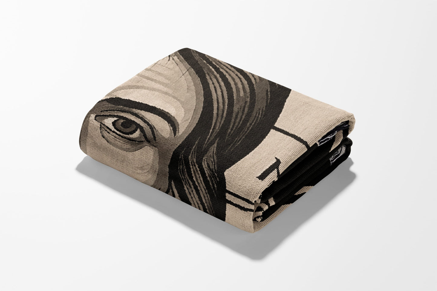 Folded blanket with a black and tan portrait design.