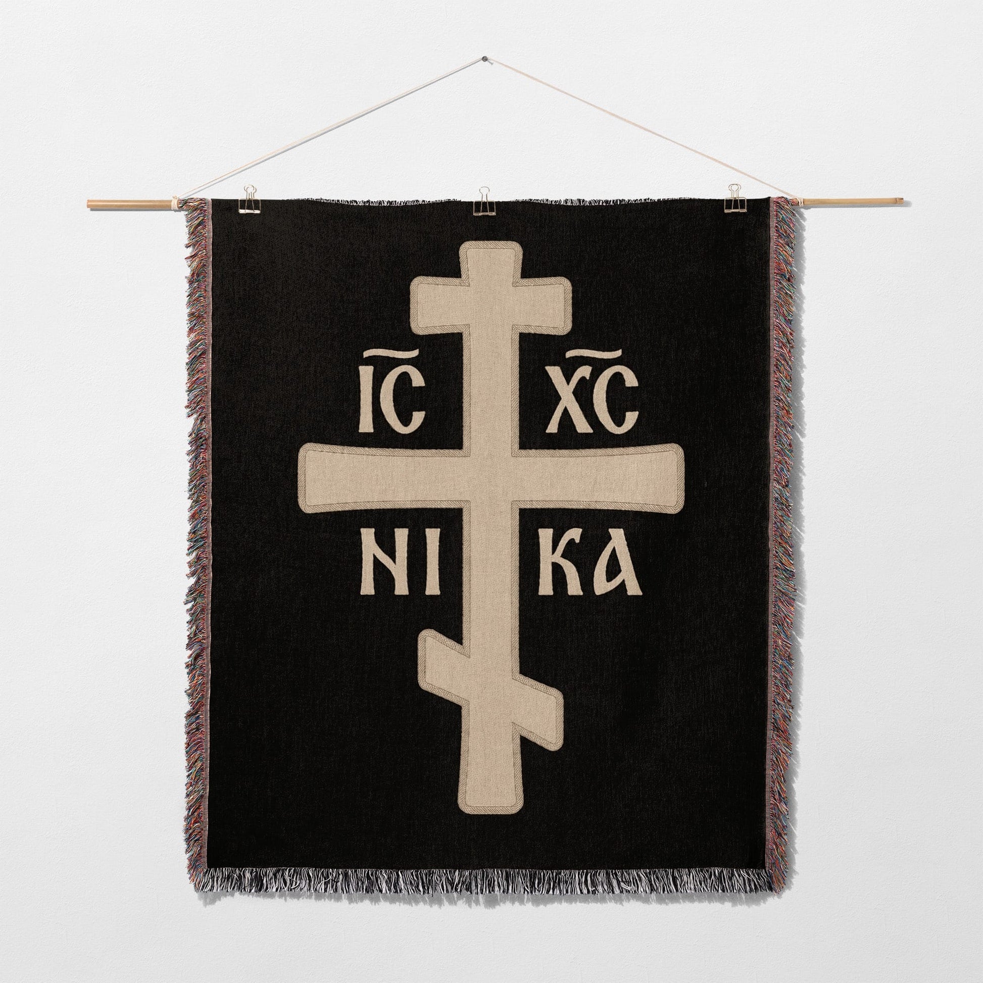 Orthodox Christian cross with IC XC NIKA inscription on black woven textile.