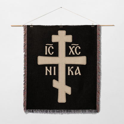 Orthodox Christian cross with IC XC NIKA inscription on black woven textile.