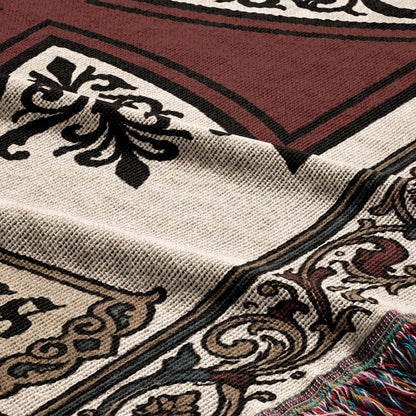 Brown and beige woven throw blanket with ornate black and tan pattern and colorful fringe.