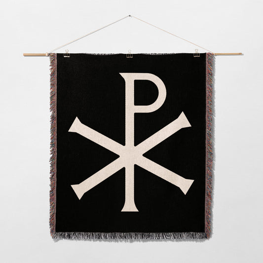 Black wall hanging with white Chi Rho symbol and fringe.