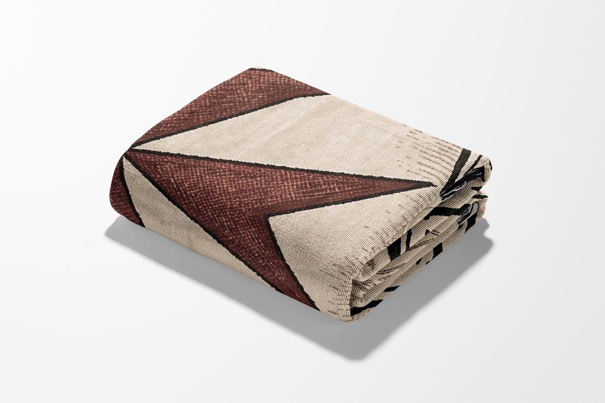 Folded throw blanket with geometric red and beige diamond pattern on white background.