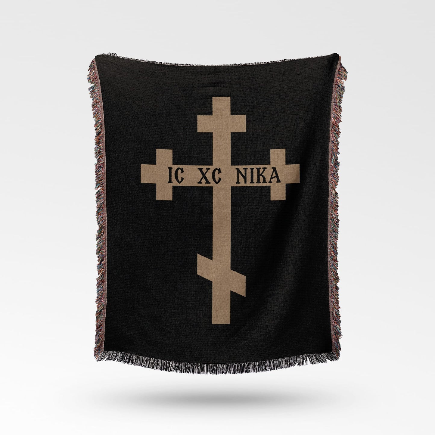 Black blanket with a tan Orthodox cross and text IC XC NIKA.