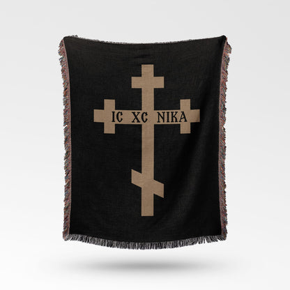 Black blanket with a tan Orthodox cross and text IC XC NIKA.