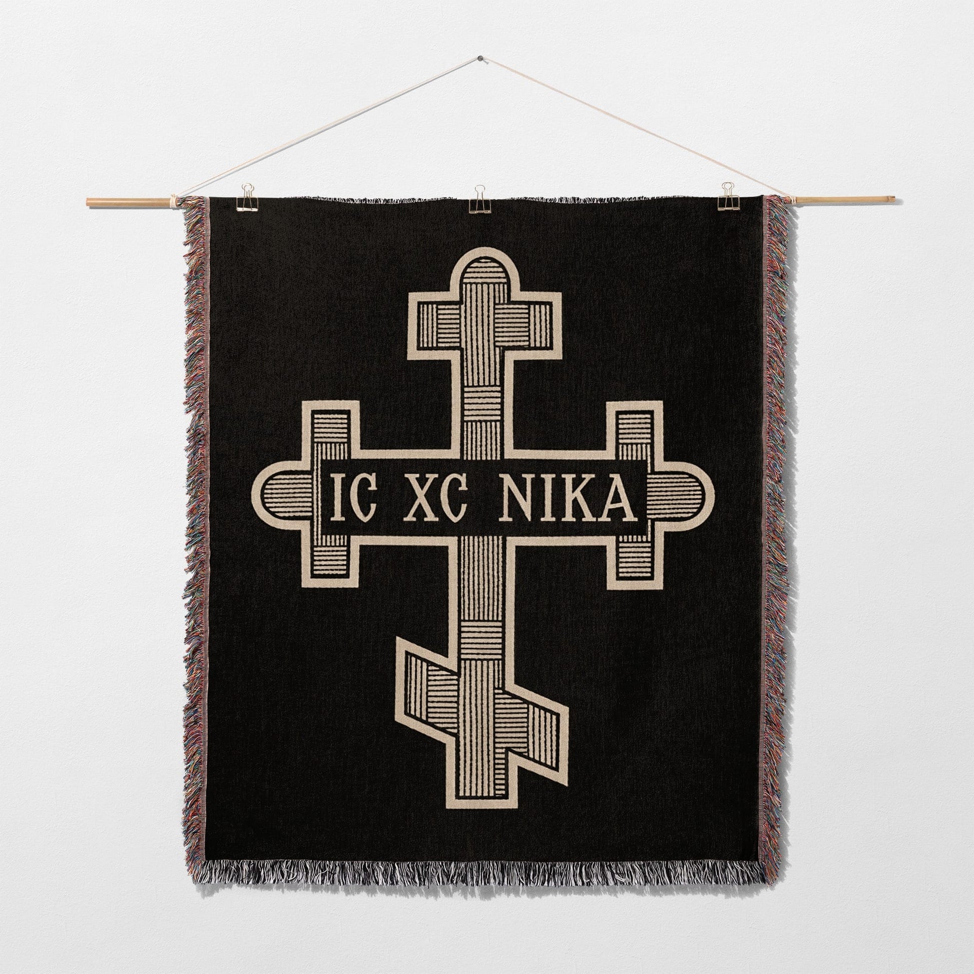 Black tapestry with a gold Byzantine cross and "IC XC NIKA" inscription.