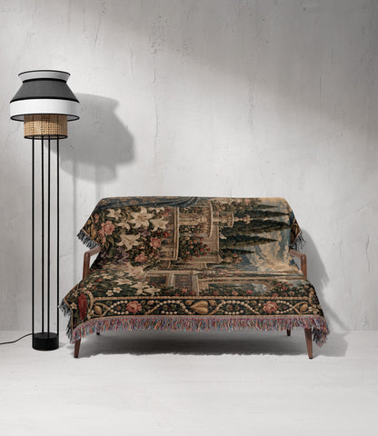 A wooden sofa covered with a decorative tapestry throw blanket beside a modern black floor lamp.