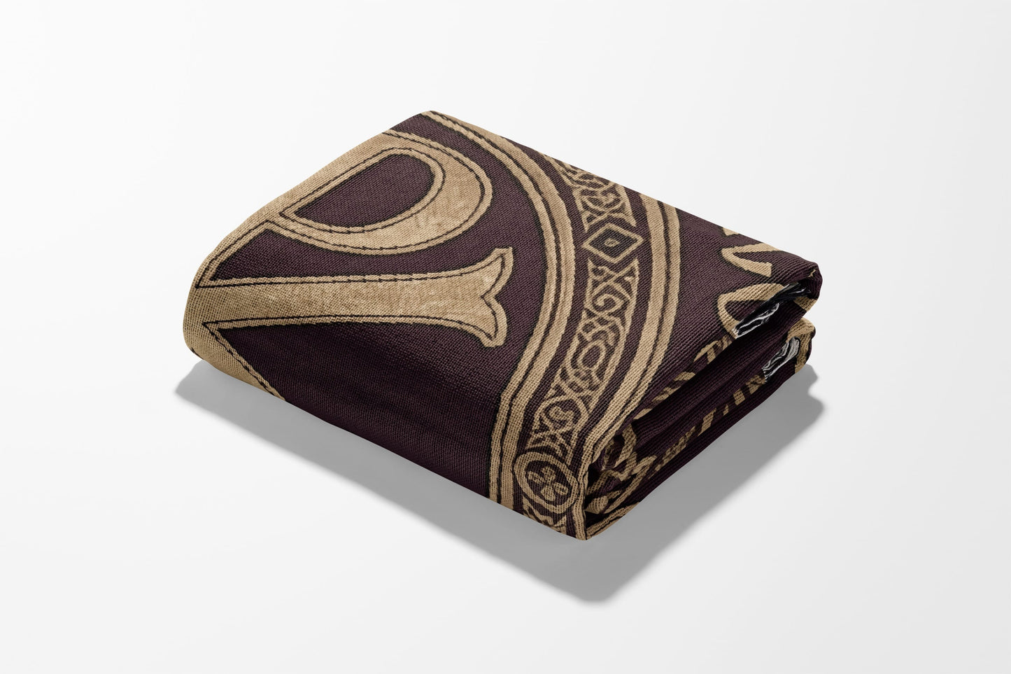 Folded brown blanket with ornate gold pattern.
