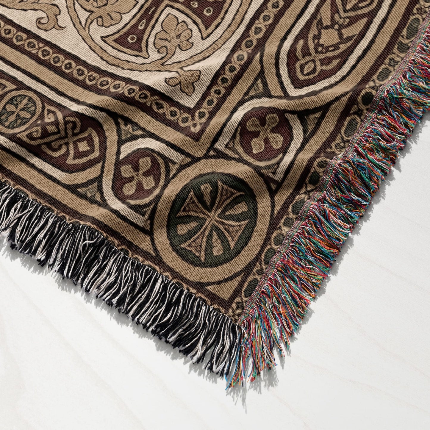 Woven tapestry blanket with fringed edge and intricate geometric pattern.