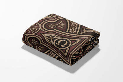 Folded patterned blanket with ornate brown and black Celtic-inspired design.