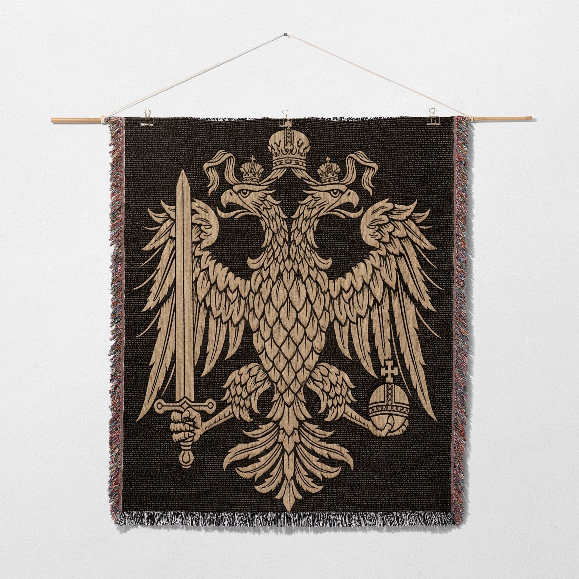 Tapestry featuring the golden double-headed eagle coat of arms on a dark background.