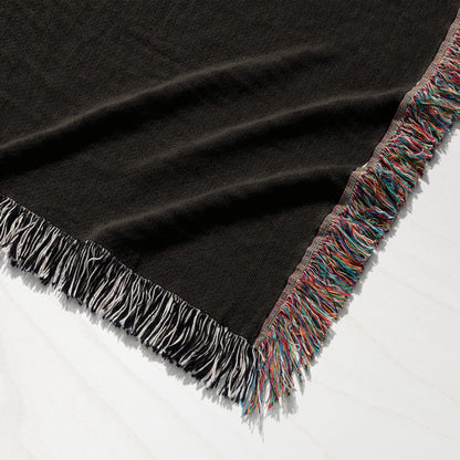 Dark brown throw blanket with colorful fringed edges.