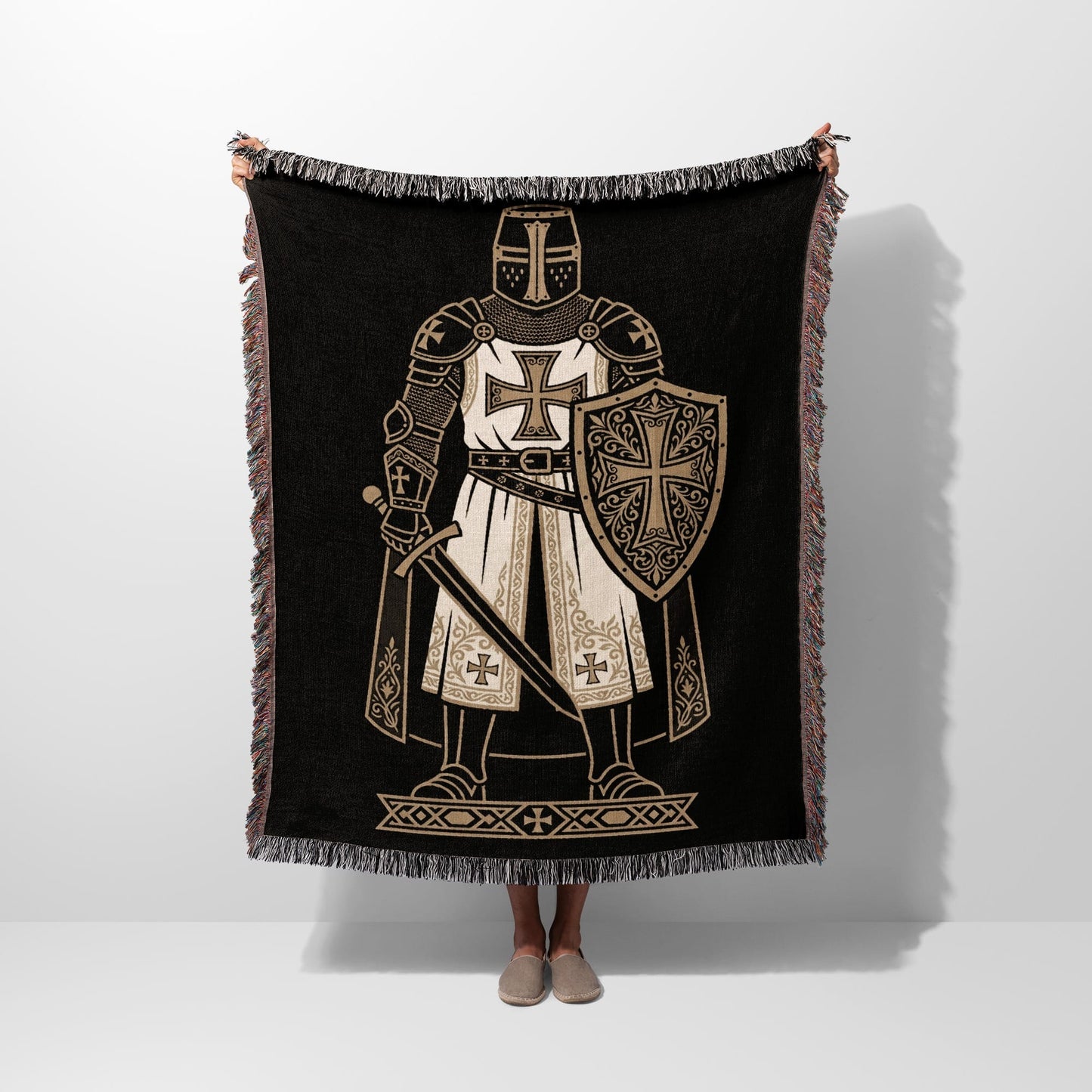 Black blanket with a knight in armor and shield, fringed edges.