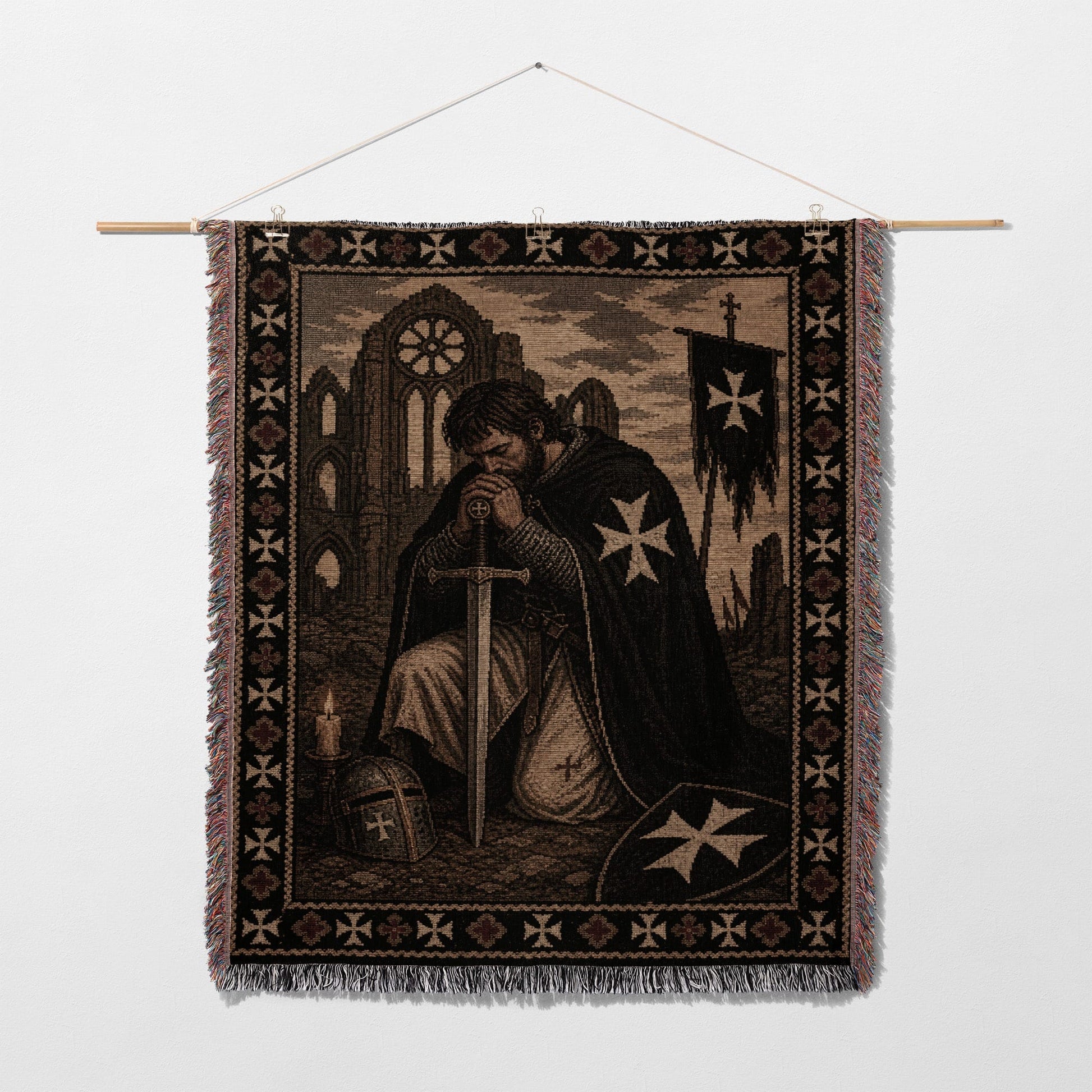 Knight in armor kneeling, praying before a sword and shield, tapestry.