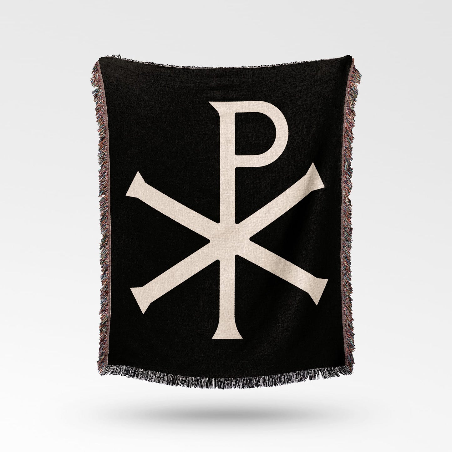 Black throw blanket with a cream Chi Rho symbol and fringed edges.