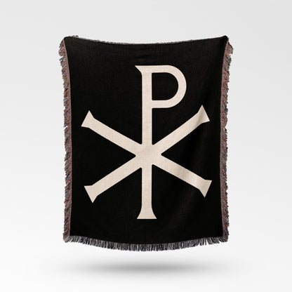 Black throw blanket with a cream Chi Rho symbol and fringed edges.