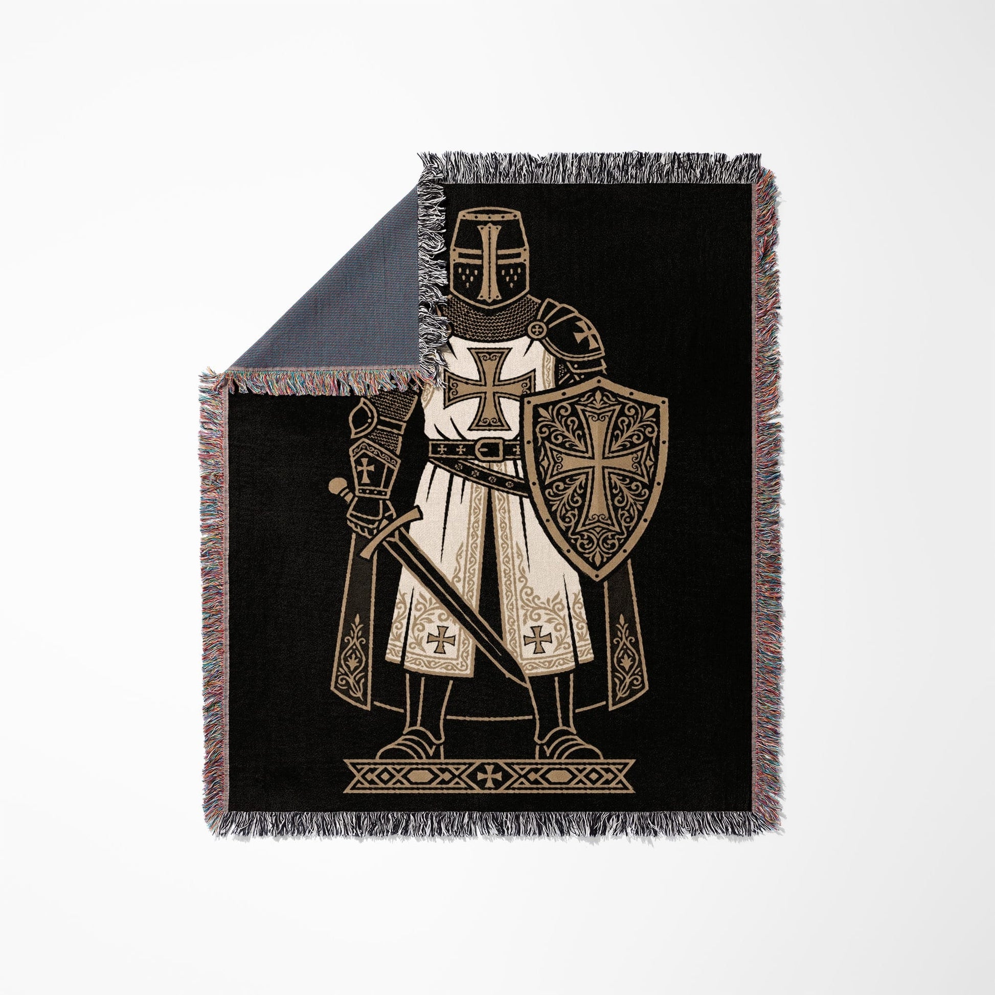 Knight in armor with sword and shield on black blanket.