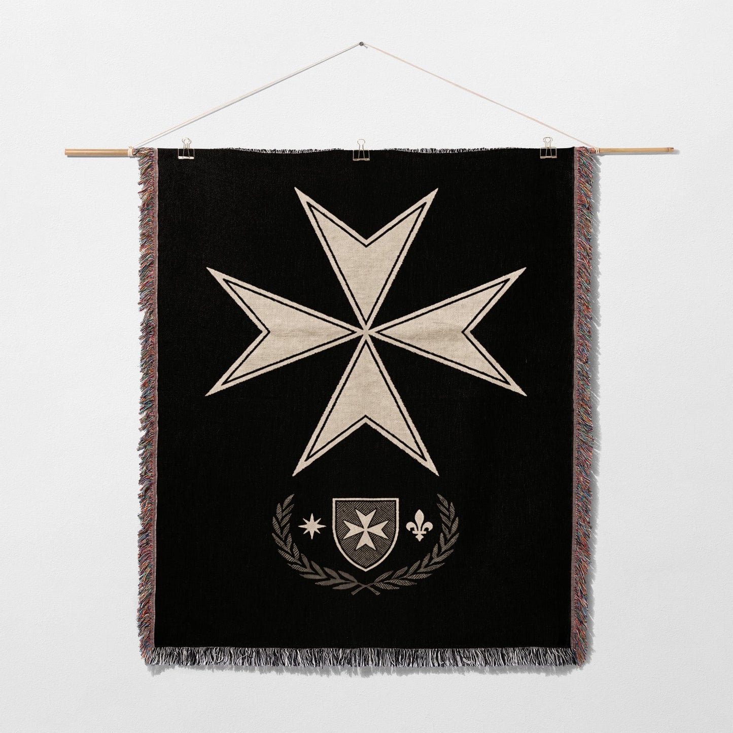 Black tapestry featuring a white Maltese cross over a shield and laurel wreath.